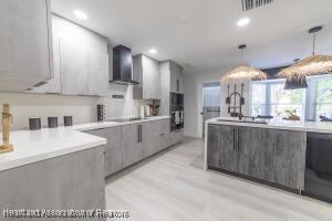 11200 S Jefferson Ave, Lake Placid, FL 33852 - kitchen featuring visible vents, gray cabinetry, wall chimney exhaust hood, and modern cabinets