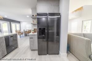 11200 S Jefferson Ave, Lake Placid, FL 33852 - kitchen with light countertops, modern cabinets, black fridge with ice dispenser, and plenty of natural light