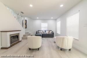 11200 S Jefferson Ave, Lake Placid, FL 33852 - living area featuring a glass covered fireplace, recessed lighting, stairway, and light wood-type flooring
