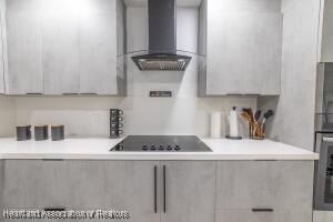 11200 S Jefferson Ave, Lake Placid, FL 33852 - kitchen with modern cabinets, wall chimney range hood, light countertops, black electric stovetop, and oven