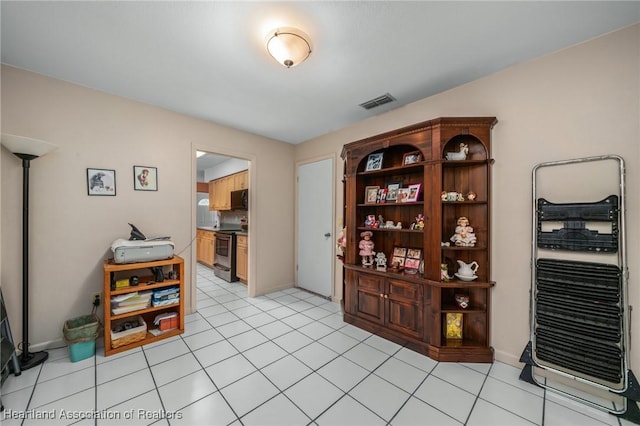 interior space with light tile patterned flooring and electric stove