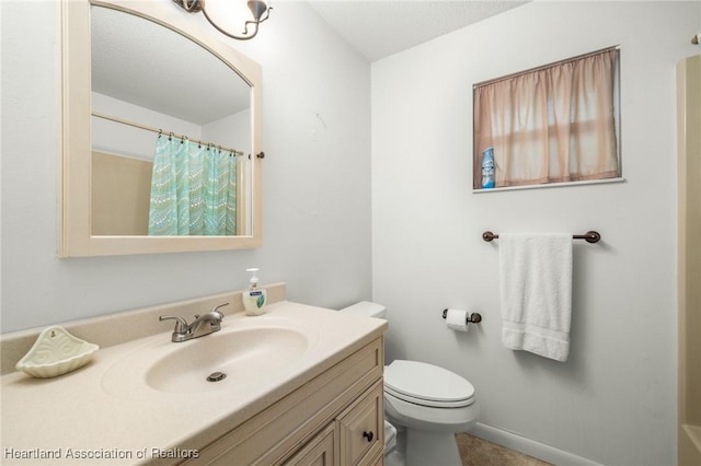 bathroom featuring a shower with curtain, vanity, and toilet