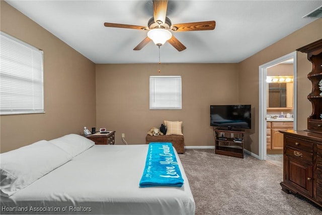 bedroom with ensuite bath, ceiling fan, and light carpet