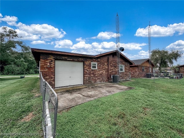 view of side of property featuring central air condition unit, a yard, and a garage