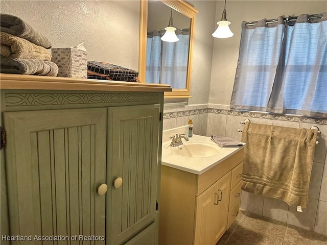 bathroom with vanity and tile walls