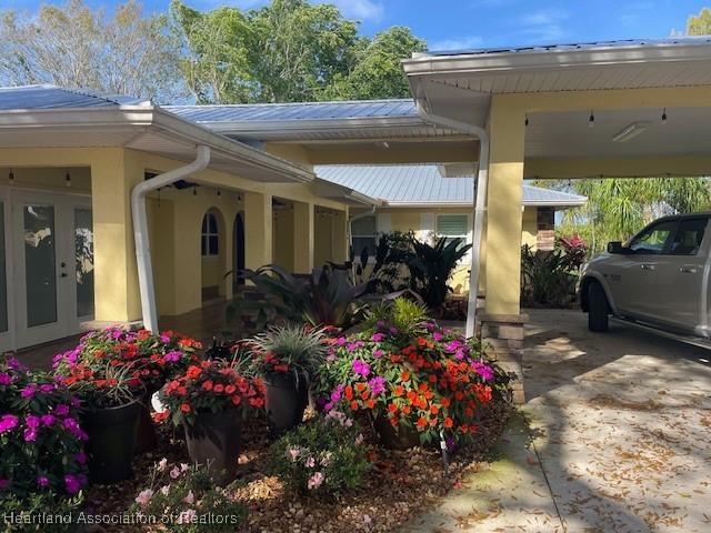 view of vehicle parking featuring a carport and french doors