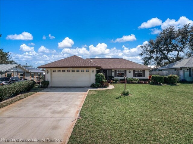 ranch-style home with a garage and a front yard