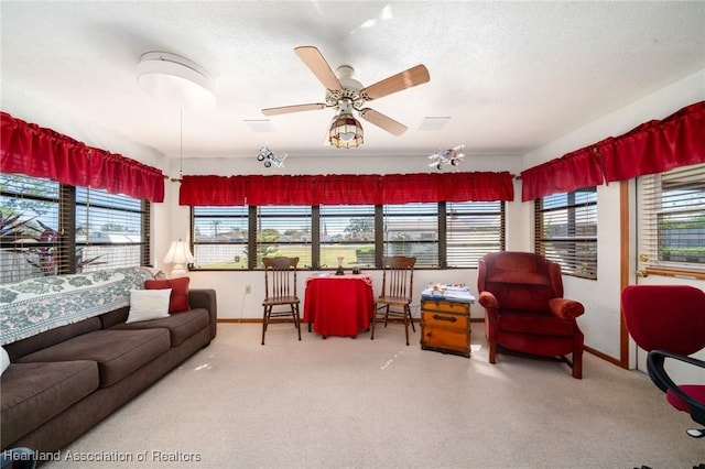 living room featuring ceiling fan, a healthy amount of sunlight, and a textured ceiling