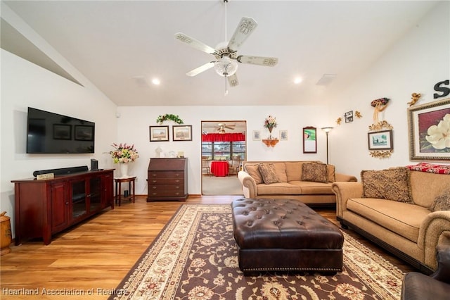 living room with vaulted ceiling, ceiling fan, and light wood-type flooring