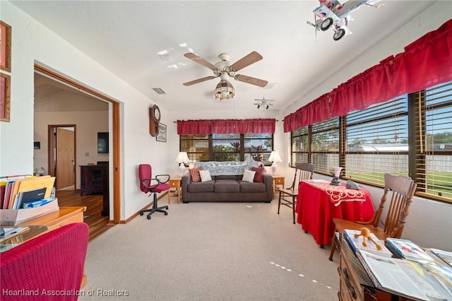 carpeted living room with ceiling fan