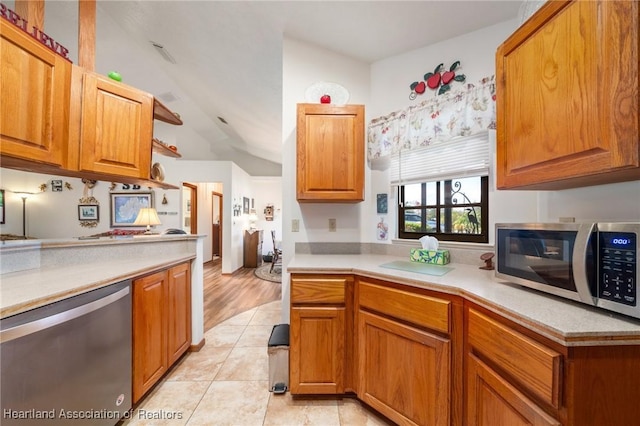 kitchen featuring appliances with stainless steel finishes, brown cabinets, light countertops, and light tile patterned floors