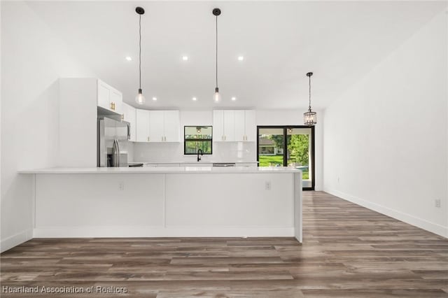 111 Blue Moon Ave, Lake Placid, FL 33852 - kitchen with stainless steel fridge with ice dispenser, light countertops, a peninsula, white cabinets, and dark wood-type flooring