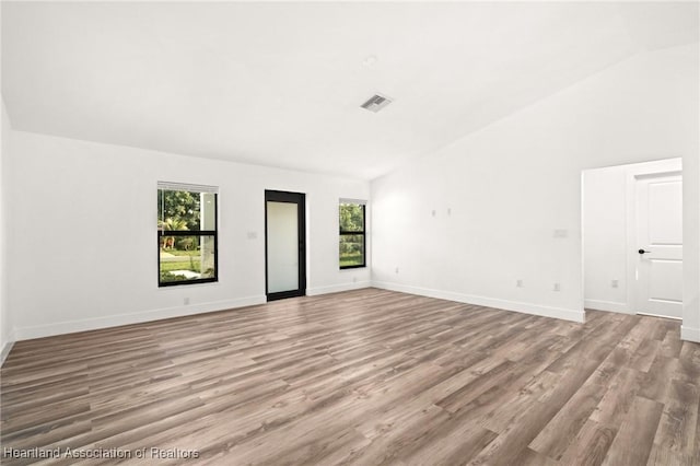 111 Blue Moon Ave, Lake Placid, FL 33852 - unfurnished room with healthy amount of natural light, lofted ceiling, light wood finished floors, and baseboards