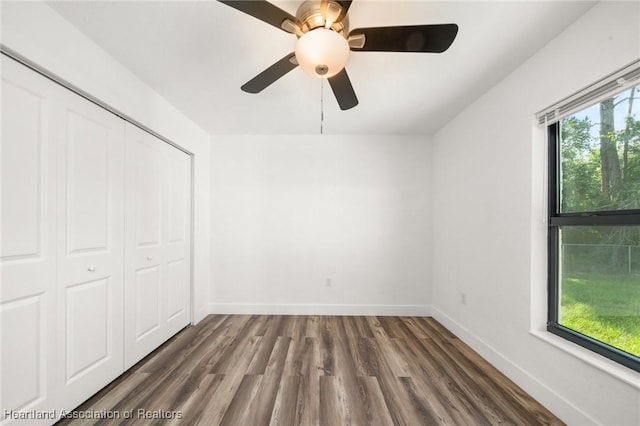 111 Blue Moon Ave, Lake Placid, FL 33852 - unfurnished bedroom with wood finished floors, baseboards, a closet, and a ceiling fan