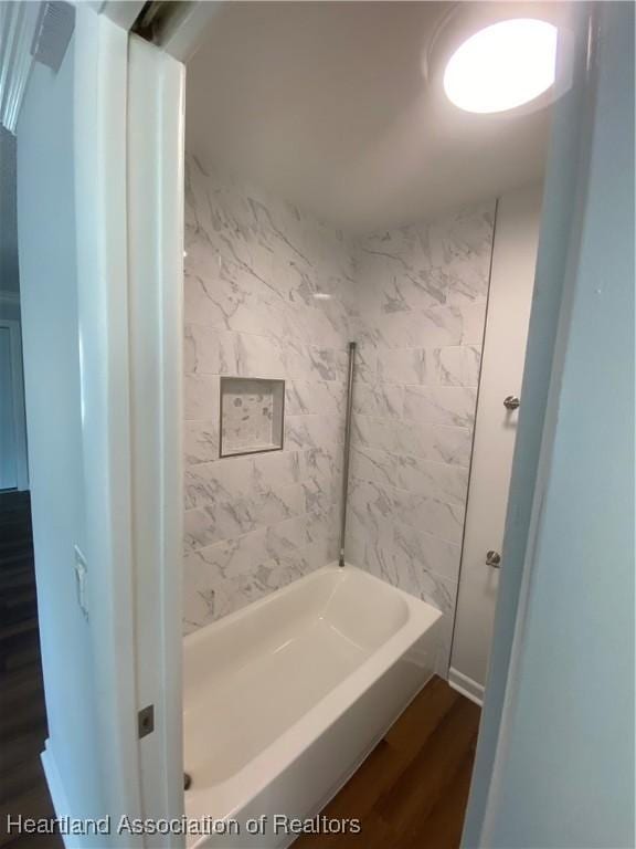 bathroom featuring tiled shower / bath combo and hardwood / wood-style flooring