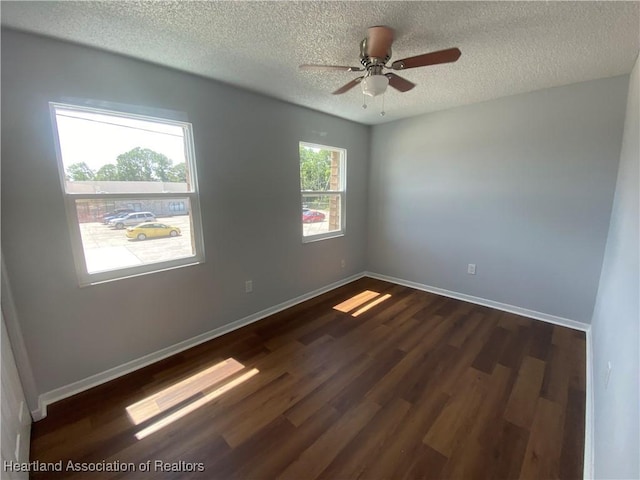 empty room with a textured ceiling, dark hardwood / wood-style floors, and ceiling fan