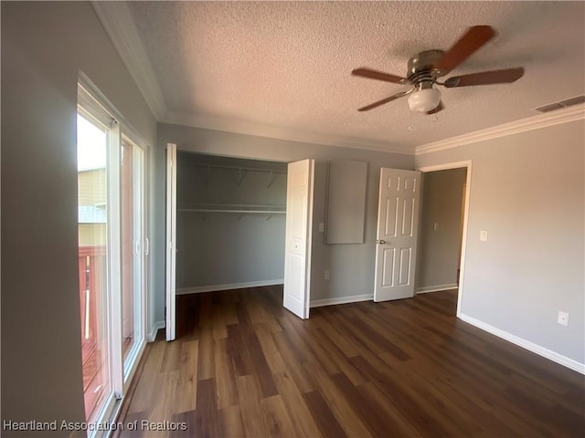 unfurnished bedroom with crown molding, ceiling fan, dark hardwood / wood-style floors, a textured ceiling, and a closet