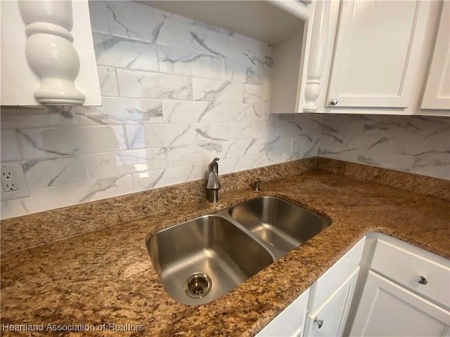 kitchen with tasteful backsplash, white cabinetry, and sink