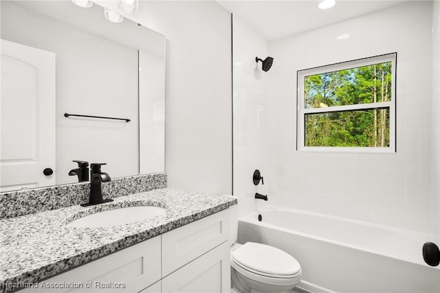 bathroom with toilet, vanity, and bathing tub / shower combination