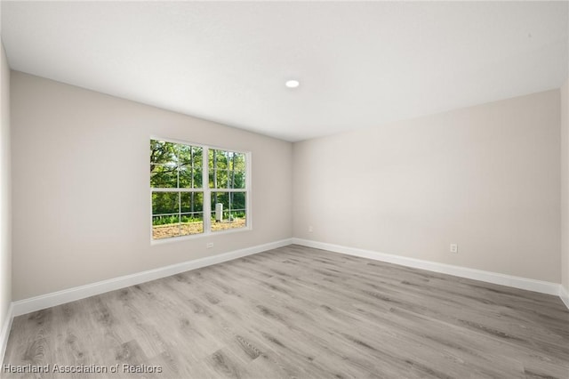 empty room featuring wood finished floors and baseboards