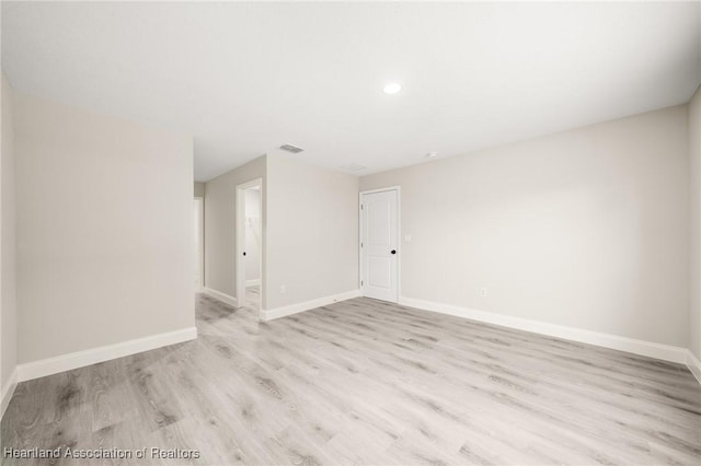 unfurnished room featuring baseboards, wood finished floors, visible vents, and recessed lighting