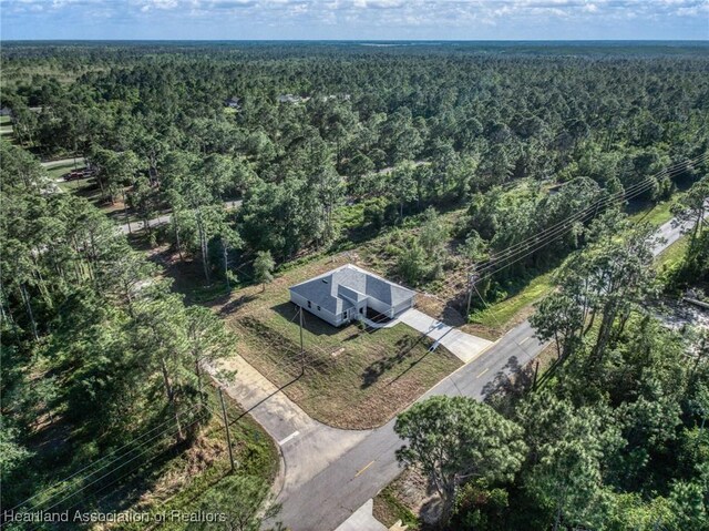 birds eye view of property featuring a view of trees