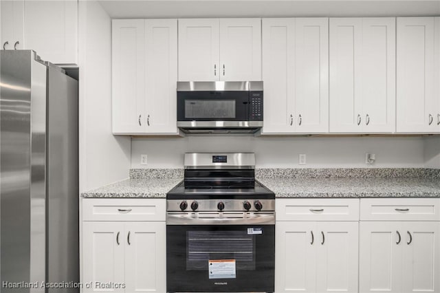 kitchen featuring white cabinets, stainless steel appliances, and light stone counters