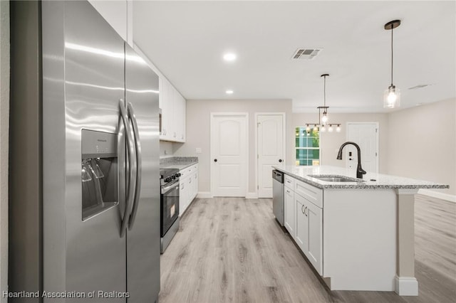 kitchen with stainless steel appliances, visible vents, a sink, and white cabinetry