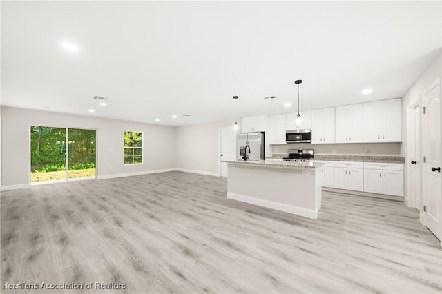 kitchen featuring an island with sink, light wood-type flooring, stainless steel appliances, white cabinetry, and recessed lighting