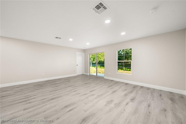 empty room with light wood-type flooring, baseboards, visible vents, and recessed lighting