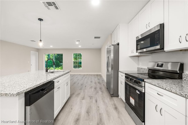 kitchen featuring white cabinets, light wood-style floors, appliances with stainless steel finishes, and a sink