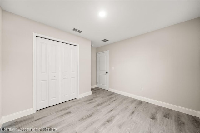 unfurnished bedroom featuring light wood-type flooring, visible vents, and baseboards