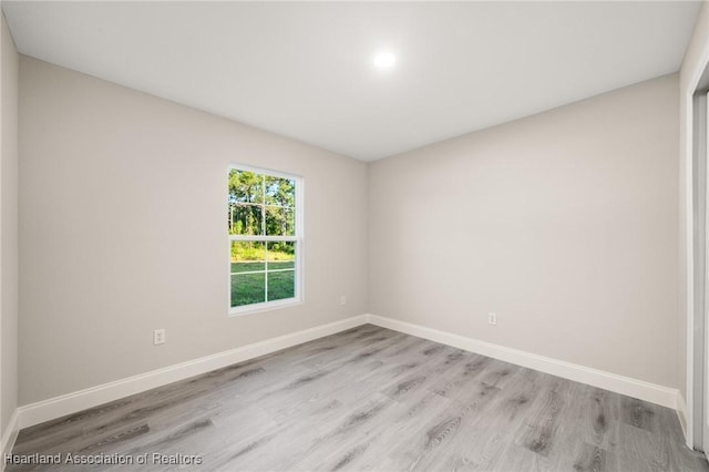 unfurnished room with baseboards and wood finished floors