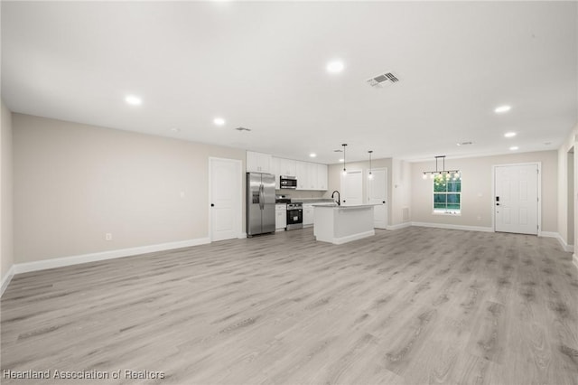 unfurnished living room featuring recessed lighting, light wood-style flooring, visible vents, and baseboards