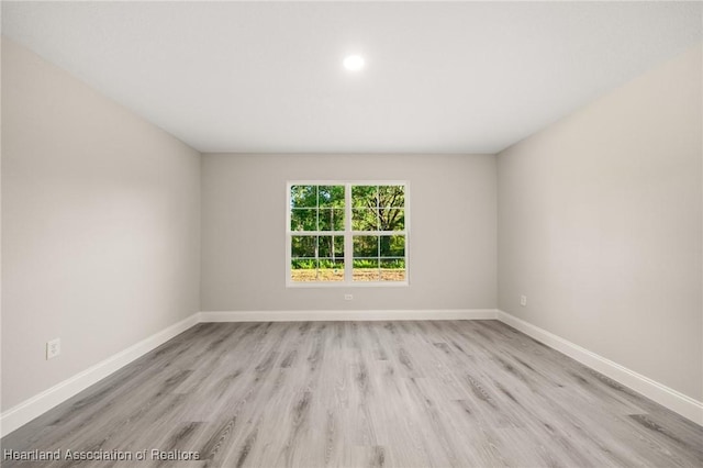 empty room with recessed lighting, baseboards, and light wood-type flooring