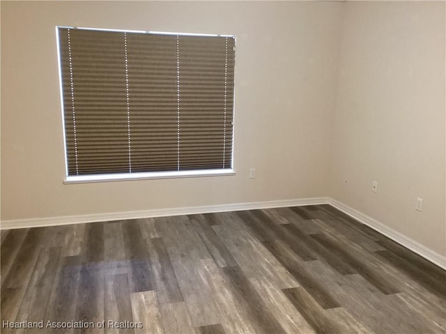 empty room with baseboards and wood finished floors