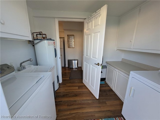 clothes washing area with cabinets, water heater, dark hardwood / wood-style flooring, and separate washer and dryer