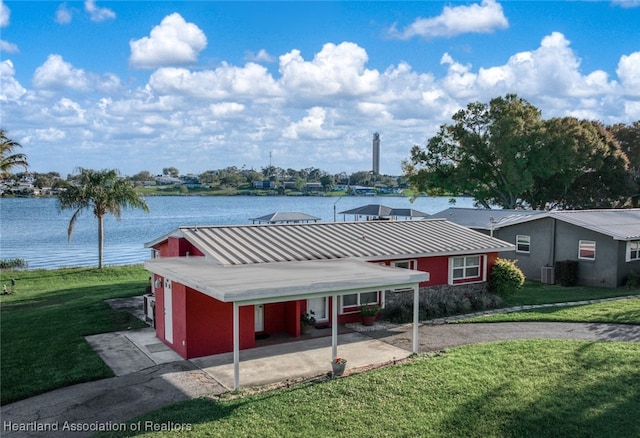 exterior space featuring a yard, a water view, and central AC unit