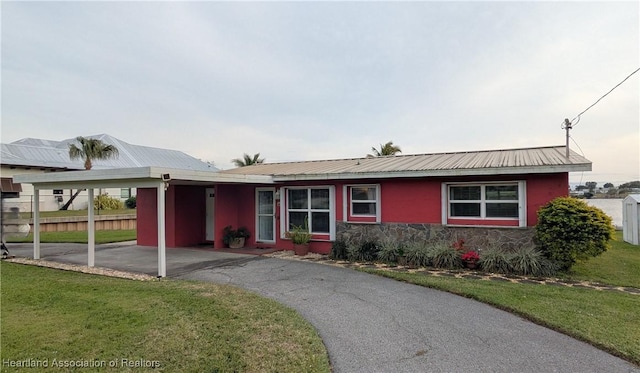 ranch-style house featuring a carport and a front yard