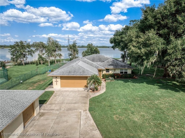 ranch-style house with a garage, a water view, and a front yard