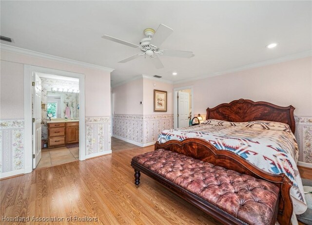 bedroom featuring ceiling fan, light hardwood / wood-style floors, crown molding, and ensuite bathroom