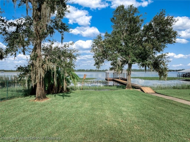 view of yard featuring a water view and a dock