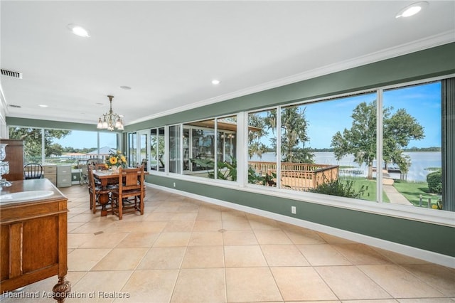 unfurnished sunroom with a water view and an inviting chandelier