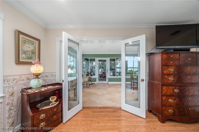 doorway to outside with french doors, ornamental molding, and light wood-type flooring