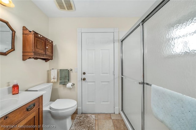 bathroom with tile patterned flooring, vanity, an enclosed shower, and toilet