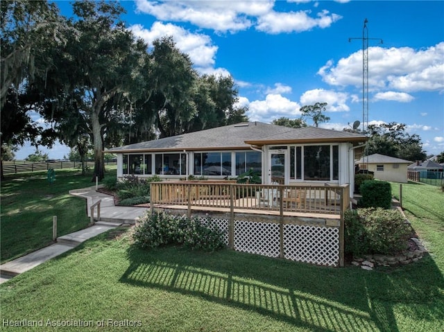 back of house featuring a wooden deck, a sunroom, and a yard