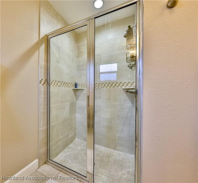 bathroom featuring tile patterned flooring and a shower with shower door