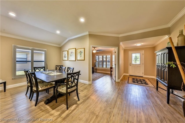 dining area featuring light wood-type flooring, vaulted ceiling, ceiling fan, and crown molding