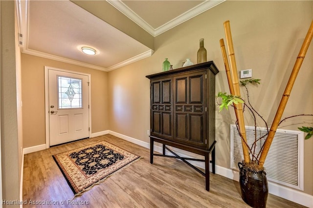 entryway with hardwood / wood-style floors and ornamental molding