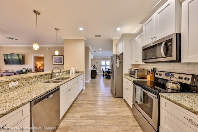 kitchen with hanging light fixtures, white cabinetry, sink, and stainless steel appliances